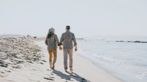 A happy retired couple walking on a beach